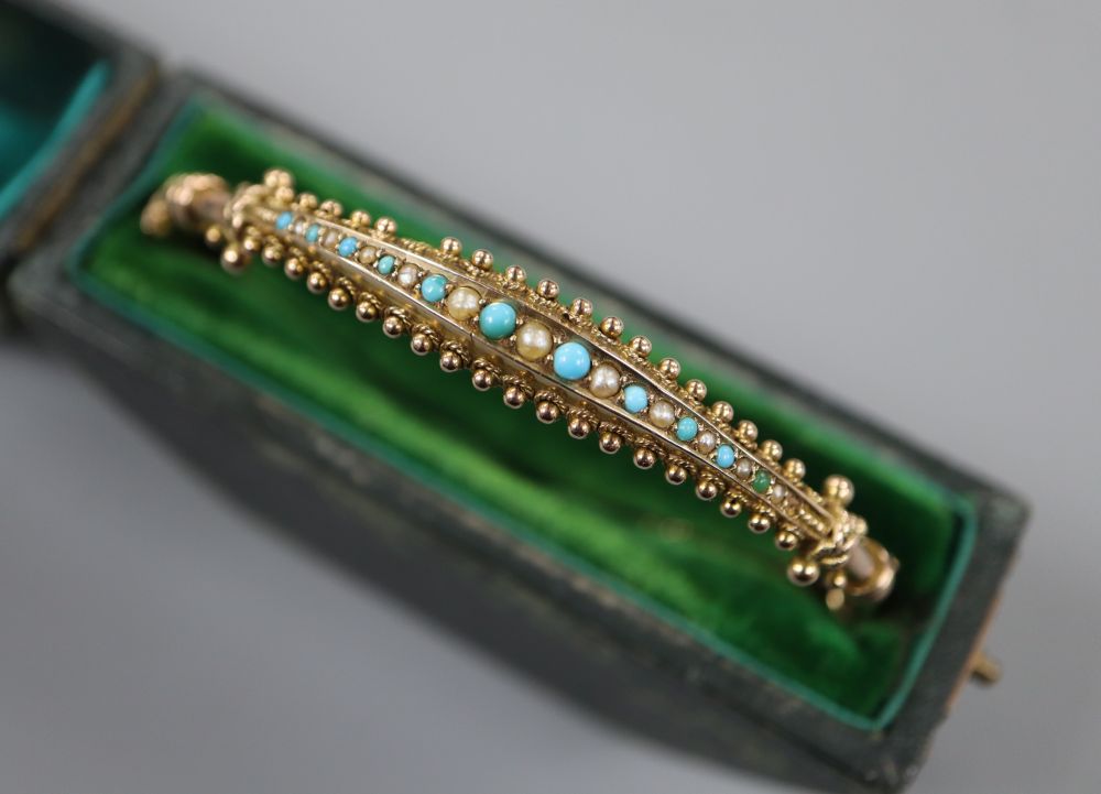A late Victorian 9ct, turquoise and seed pearl set hinged bangle, in fitted box, gross 6.7 grams.